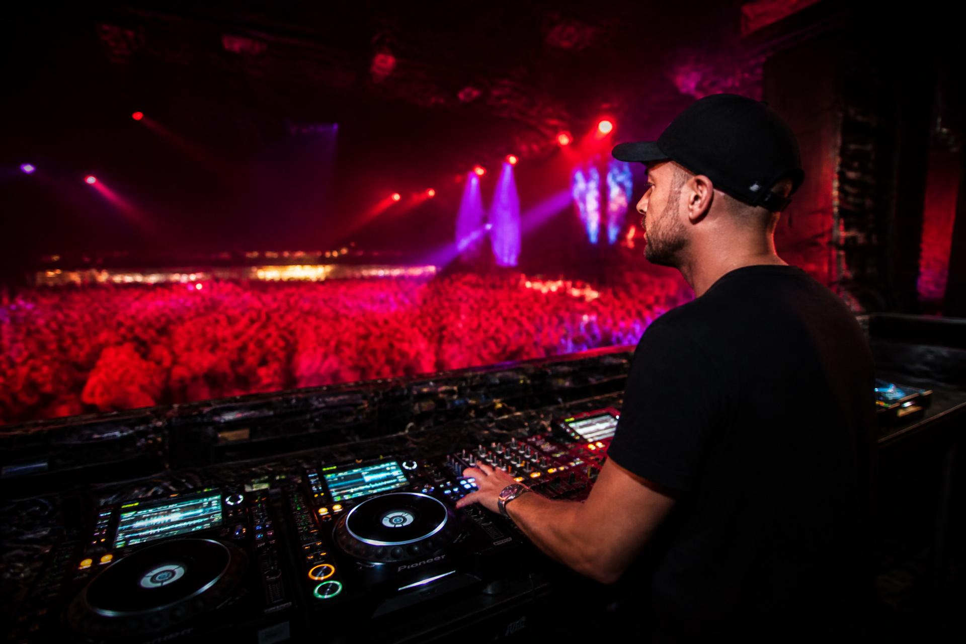 ANS Productions DJ performing under red stage lights